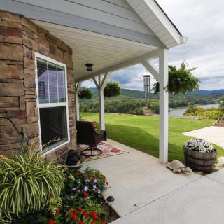 A scenic view from a cozy porch with a garden and surrounding landscape.