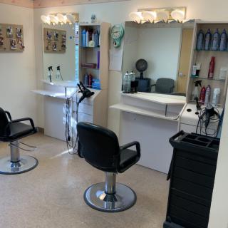 A tidy hair salon interior with styling chairs and mirrors.