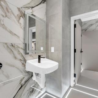 A modern bathroom featuring elegant marble walls and stylish fixtures.