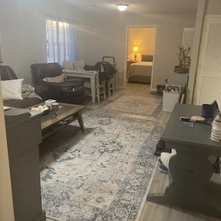 A cozy living room setup featuring a soft rug and comfortable furniture, enhanced by warm lighting.