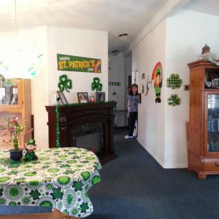 A living room decorated for St. Patrick's Day with shamrock-themed decorations and a festive tablecloth.
