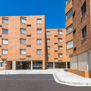 A modern brick apartment building under a clear blue sky.