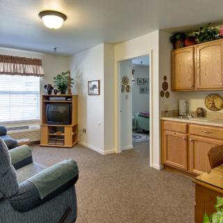 Cozy living room with a television and kitchenette.