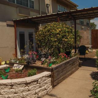 A charming backyard garden with raised flower beds and a patio.