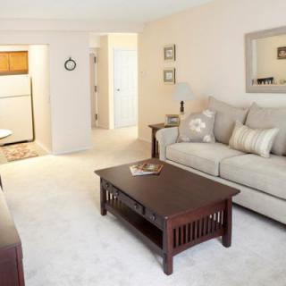 A cozy living room with a sofa and coffee table, featuring neutral tones and simple decor.