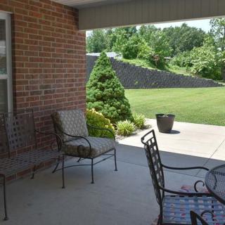 A peaceful patio area with metal chairs overlooking a well-maintained garden.