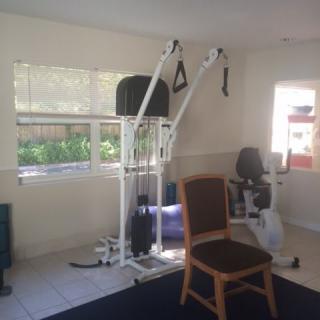 A home gym setup featuring exercise equipment and a chair.