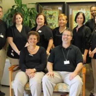 A group of professionals posing for a team photo in an office setting.