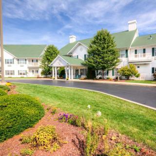A sunny day view of a building with a green roof and landscaped gardens.