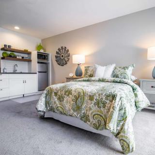A modern and cozy bedroom featuring a stylish bed with patterned bedding, two bedside lamps, and minimalistic decor.