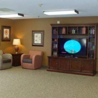 A cozy living room with armchairs, a television, and an entertainment center.