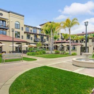 A beautiful courtyard with a fountain and landscaped greenery, surrounded by a residential building.