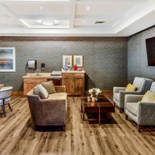 A modern lounge area featuring comfortable seating with armchairs and a coffee table on a hardwood floor.