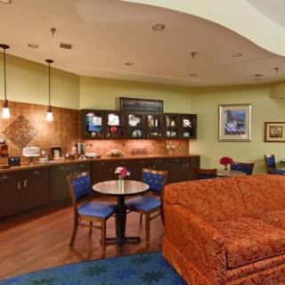 A cozy kitchen and dining area with a coffee station, warm lighting, and comfortable seating.
