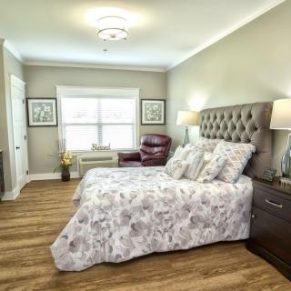 A cozy bedroom with a floral-patterned bedspread, tufted headboard, and elegant decor.