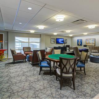 A spacious lounge featuring comfortable seating, a gaming table, and a television.