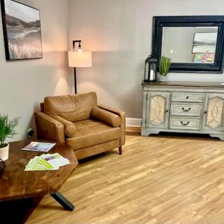 A cozy and inviting living area featuring a leather armchair, wooden table, and stylish decor.