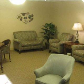 A cozy living room with sofas, armchairs, a lamp, and decorative elements.