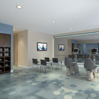 A modern waiting area featuring comfortable seating and wall-mounted televisions.