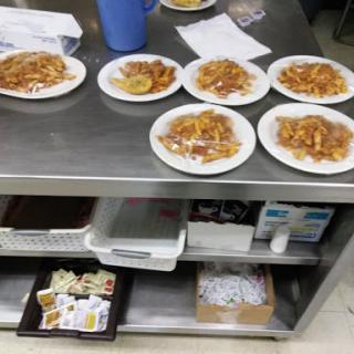A countertop in a kitchen displaying several plates of food, ready for serving.