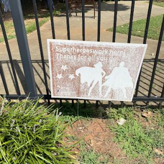A decorative sign displayed on a fence, showcasing an artistic representation.