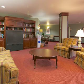 A cozy living room with comfortable seating, bookshelves, and warm lighting.