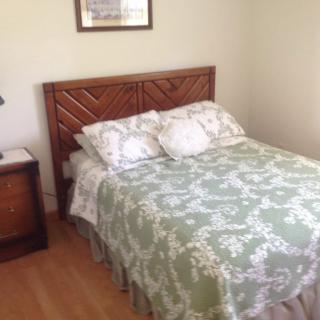 A cozy bedroom with a neatly made bed and bedside table.