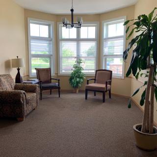 A cozy corner in a living room with comfortable seating and natural light streaming through the windows.