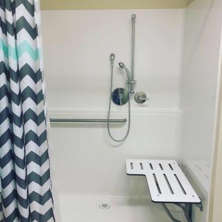 Accessible shower with a seat and grab bar.