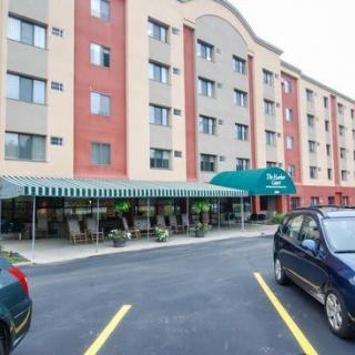 A view of a hotel building with a parking lot and cars in front.