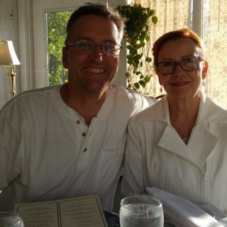 A smiling couple sitting at a restaurant table.