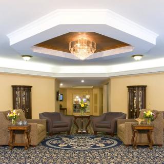 A well-furnished lobby featuring comfortable seating and a central chandelier.
