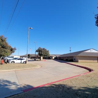 A view of a parking lot and building under a clear blue sky.