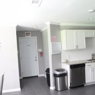 A modern kitchen with white cabinets and stainless steel appliances.