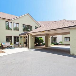 A residential building with a covered entrance and driveway on a sunny day.