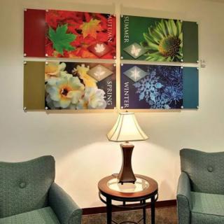 A cozy seating area with a lamp and seasonal artwork on the wall.