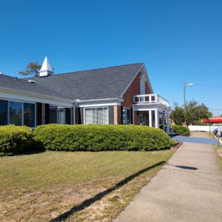 A charming building surrounded by greenery on a clear day.