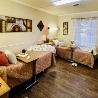 A cozy shared bedroom with two single beds, stylish decor, and a large window allowing natural light.