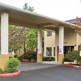 Entrance of a hotel with a covered driveway and columns.