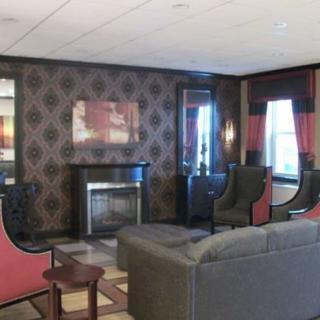 A cozy lounge area featuring stylish chairs, a sofa, and a decorative fireplace.
