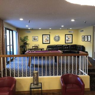 A cozy living room featuring a pool table, comfortable sofas, and artwork on the walls.
