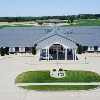 Aerial view of a large building with a landscaped entrance and circular driveway.