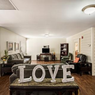 A cozy living room with elegant furniture and a decorative 'LOVE' sign.