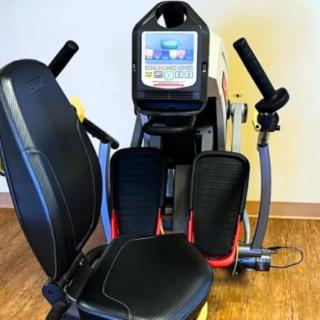 A recumbent stepper machine designed for indoor workouts, featuring a comfortable seat and digital display.