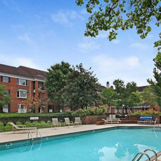 A serene outdoor pool surrounded by apartment buildings and lush greenery.