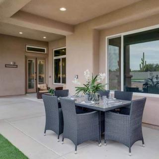 A modern outdoor patio with a dining set and comfortable seating under a covered area.