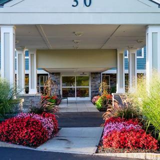 A beautifully landscaped entrance to a building with vibrant flowers lining the pathway.