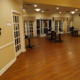 A spacious dining area with wooden flooring and cozy seating arrangements.