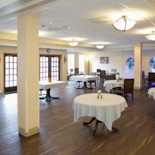 An empty restaurant dining area with round tables and chairs arranged neatly.