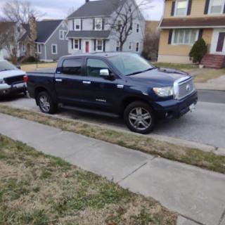 A blue truck parked alongside a residential street.